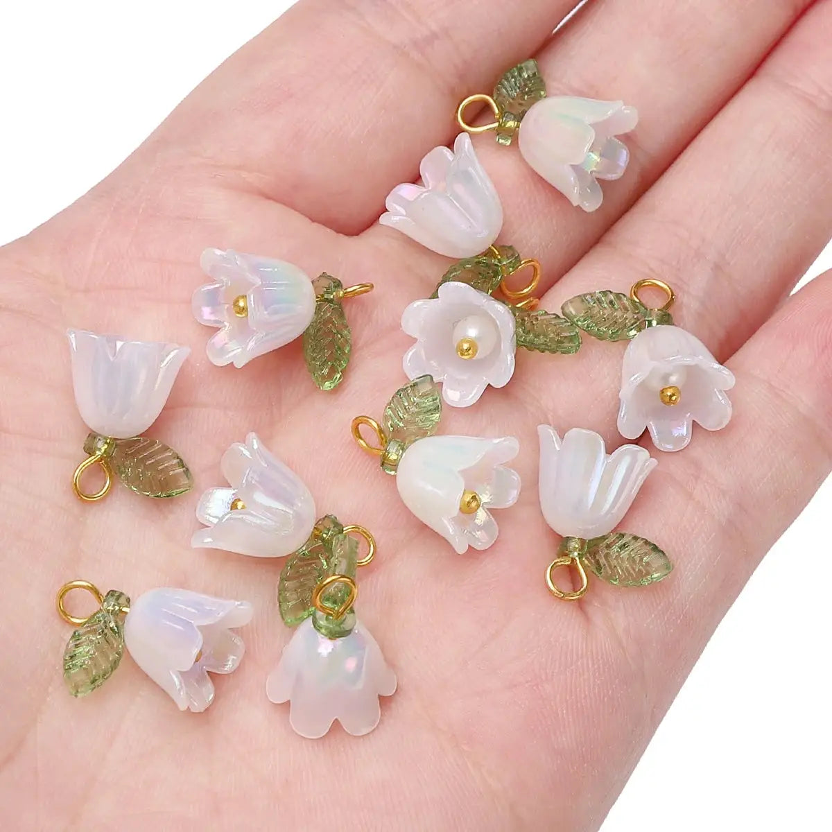 11x14mm acrylic lily-of-the-valley flower beads with iridescent white petals, green leaves and gold loops, 2–10 pcs.