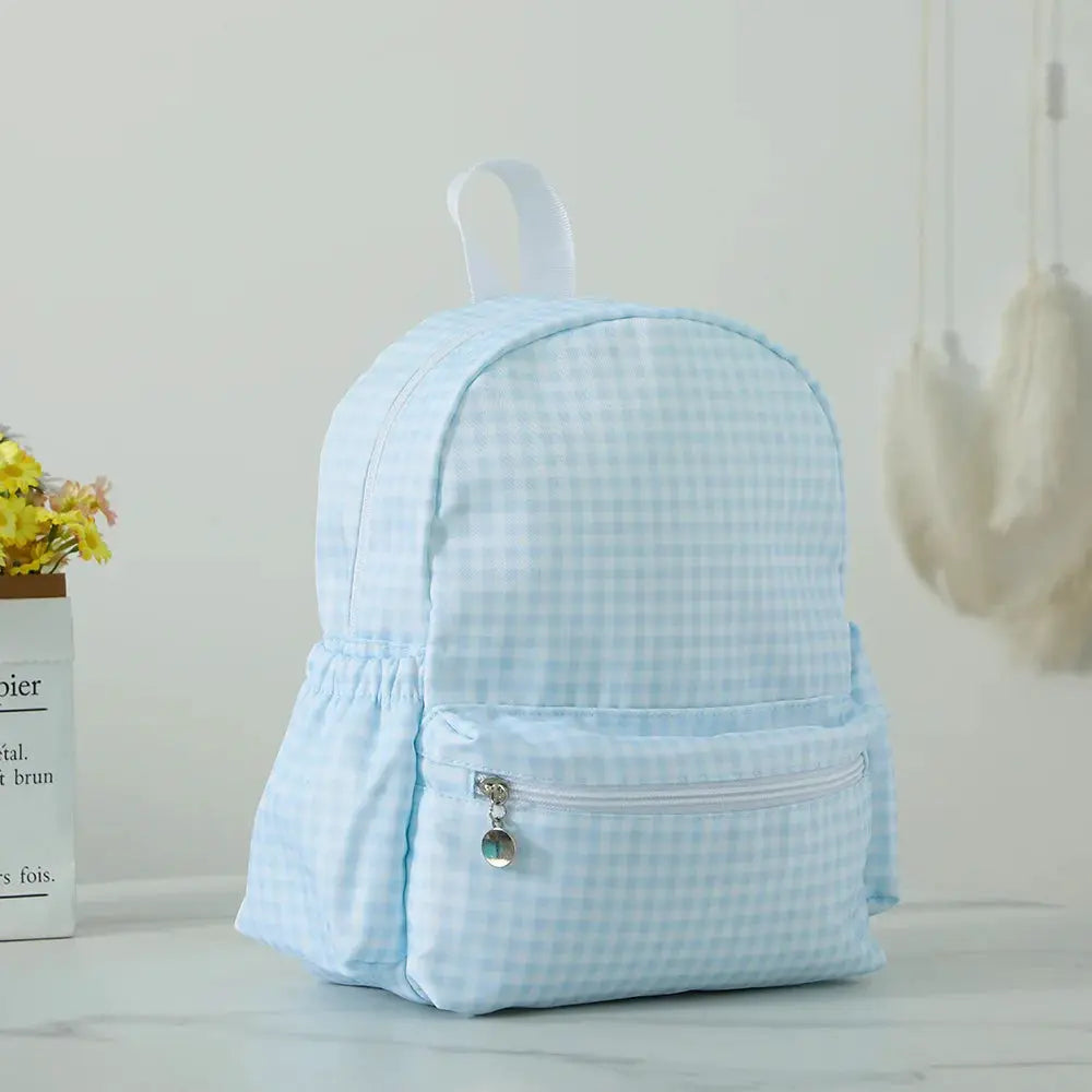 Toddler backpack in light-blue gingham fabric with front zipper pocket