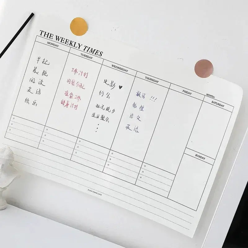 White weekly planner notebook with grid layout and undated daily columns for scheduling