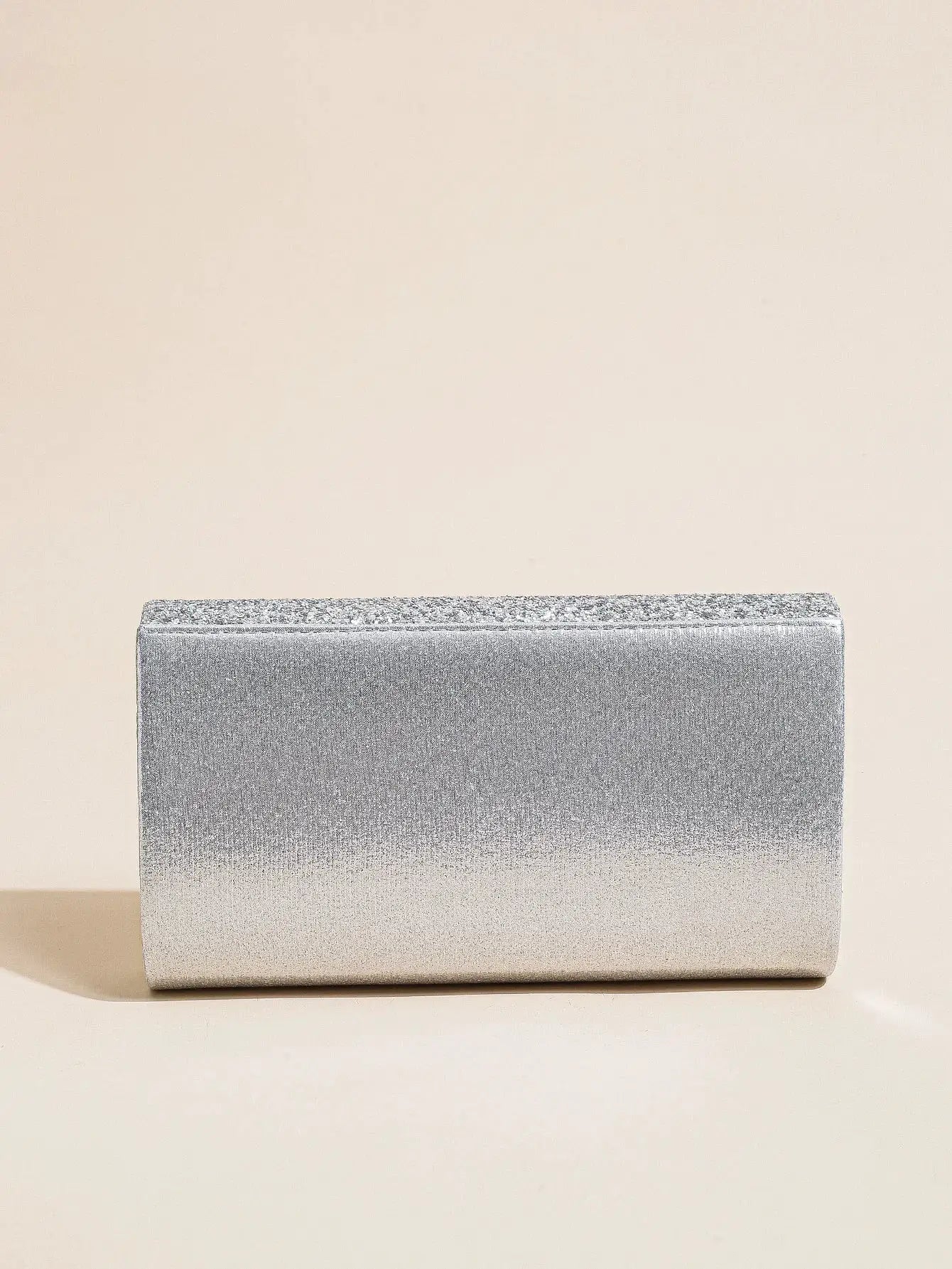 Silver metallic envelope clutch bag with glittery top edge.