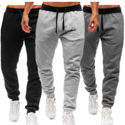 Men's loose straight-leg jogger pants set in three colors: black, light grey, dark grey with drawstring waist and cuffed ankles.