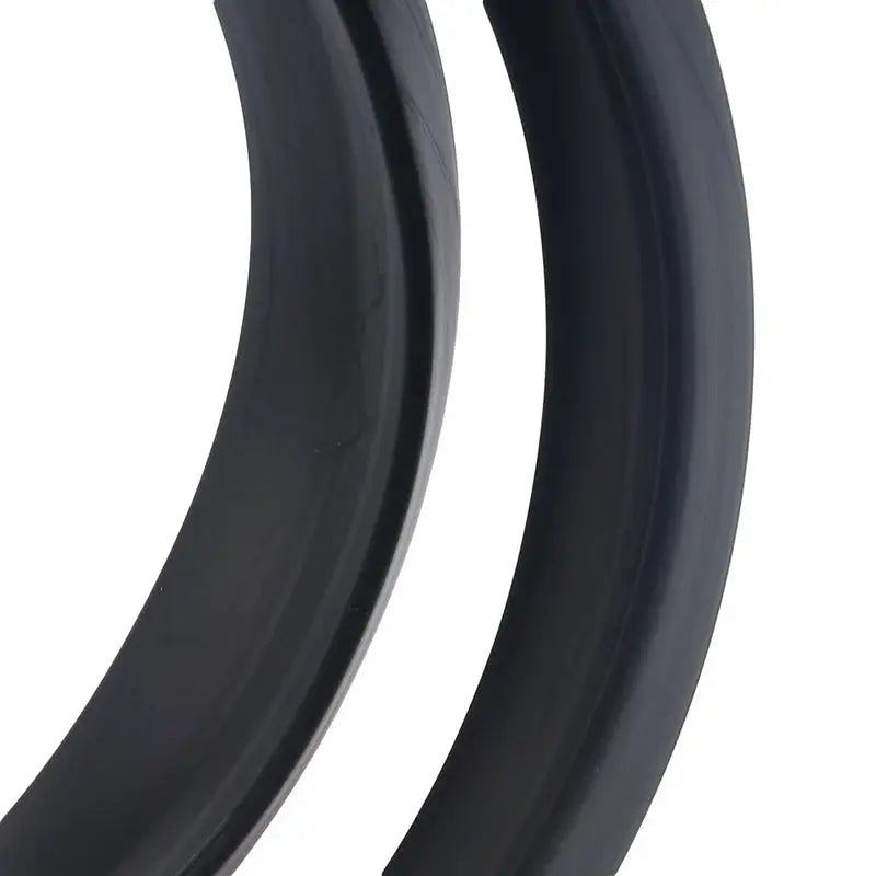 Two black carbon fiber look car spoiler trims, curved and glossy.