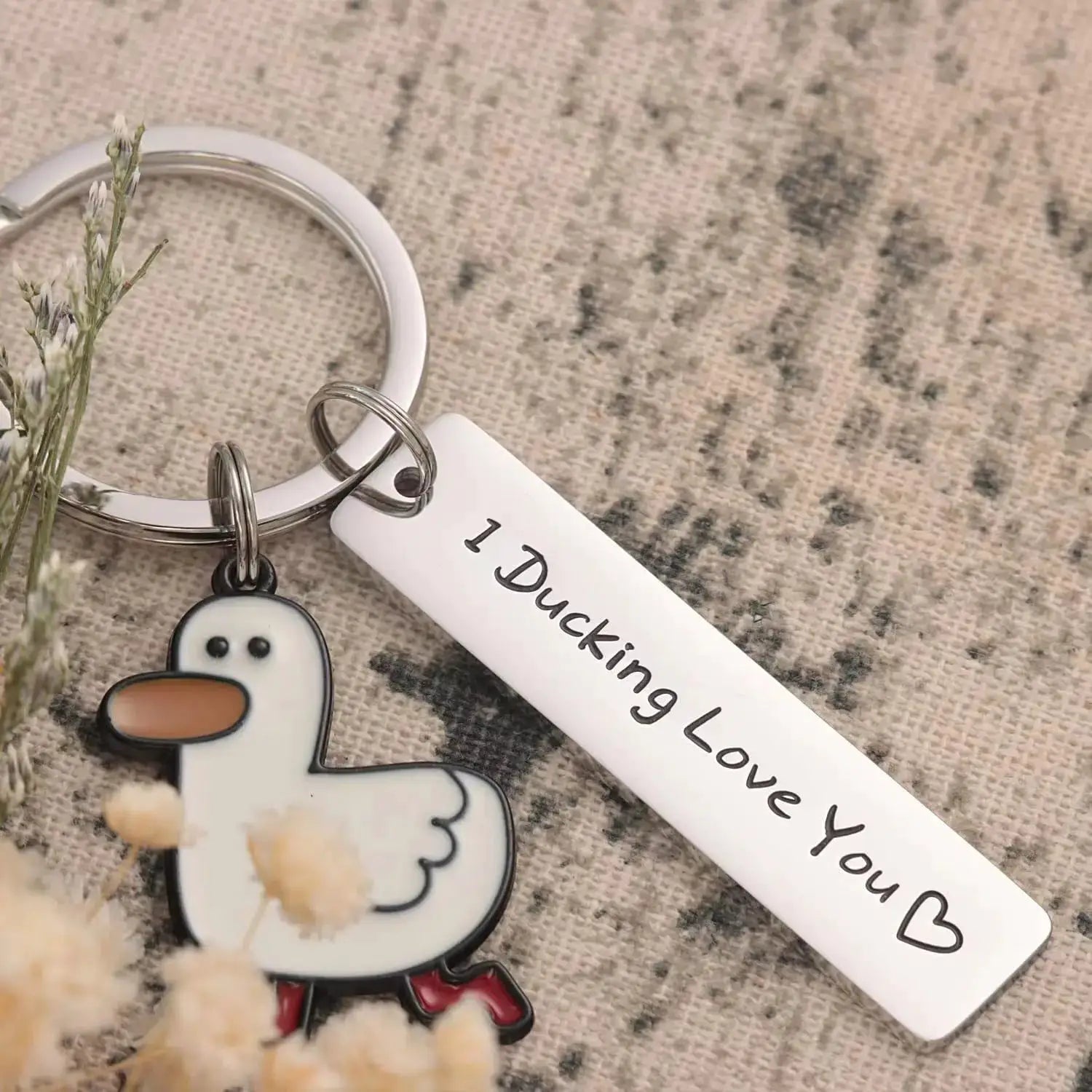 Keychain with white duck charm, orange beak, and silver ring; tag reads I Ducking Love You