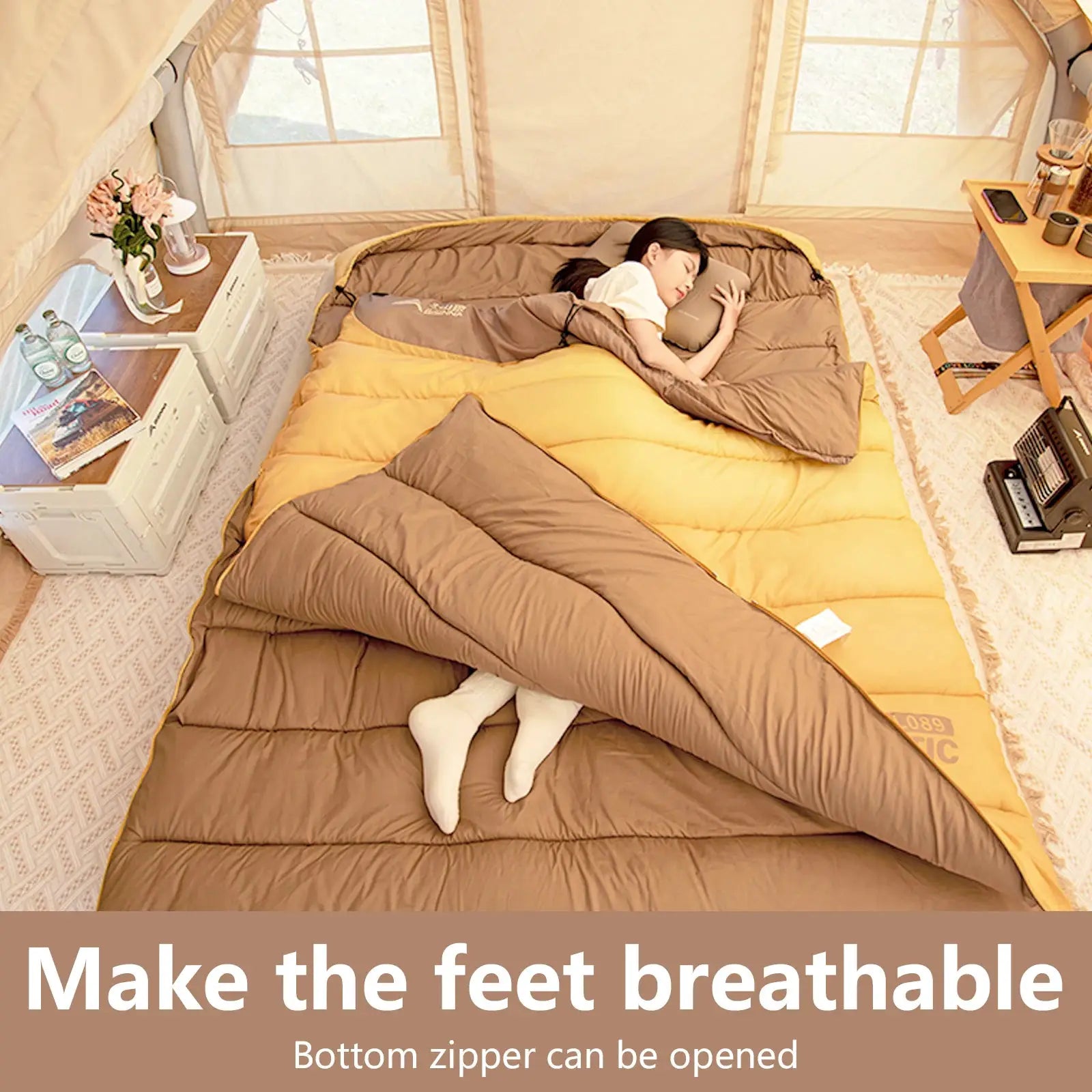 BISINNA 2-person camping sleeping bag in brown and mustard yellow, inside a tent with a person resting.