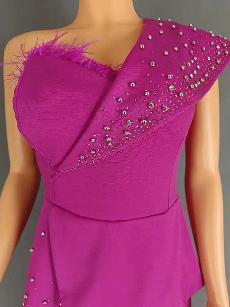 Magenta high-waist jumpsuit with rhinestone-embellished diagonal bodice and feather trim