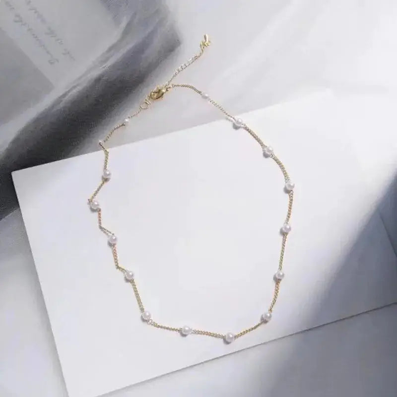 Gold-tone pearl choker necklace for women with evenly spaced white pearls Simples Market