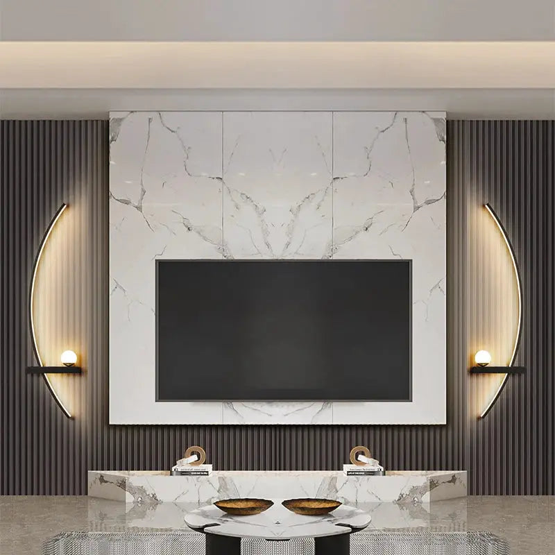 LED wall lamps by Simples Market; two black dual-arc sconces with warm glow beside marble TV wall.