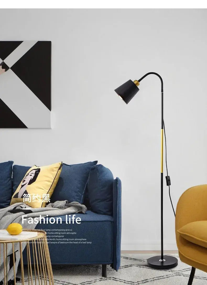 Floor lamp black metal with gold accents adjustable head beside blue sofa and yellow chair