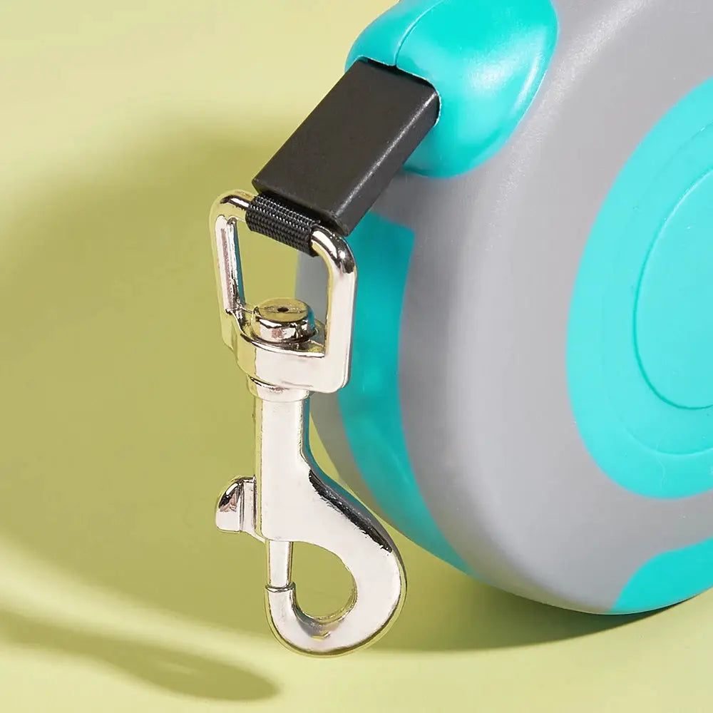 Retractable dog leash by Simples Market, turquoise and gray plastic housing with metal clip