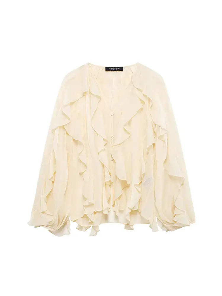 Women's ivory loose ruffled blouse with cascading frills and long puff sleeves.