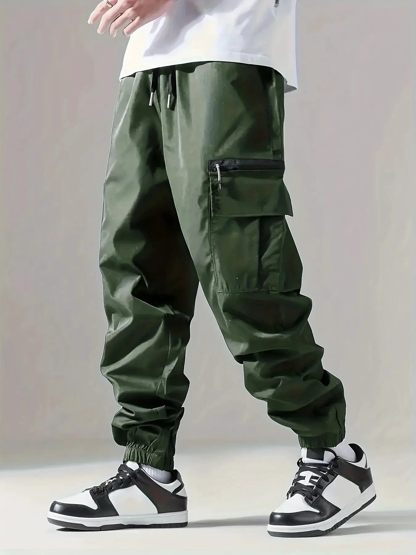 Men's cargo pants in olive green with multiple pockets, drawstring waist, and elastic cuffs