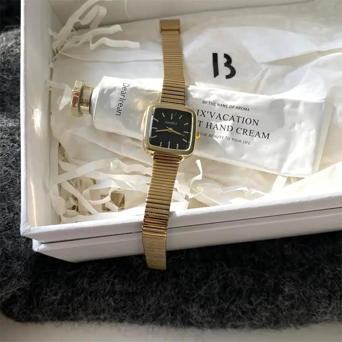 NAIDU women's quartz watch with square black dial and gold-tone stainless steel band in a gift box