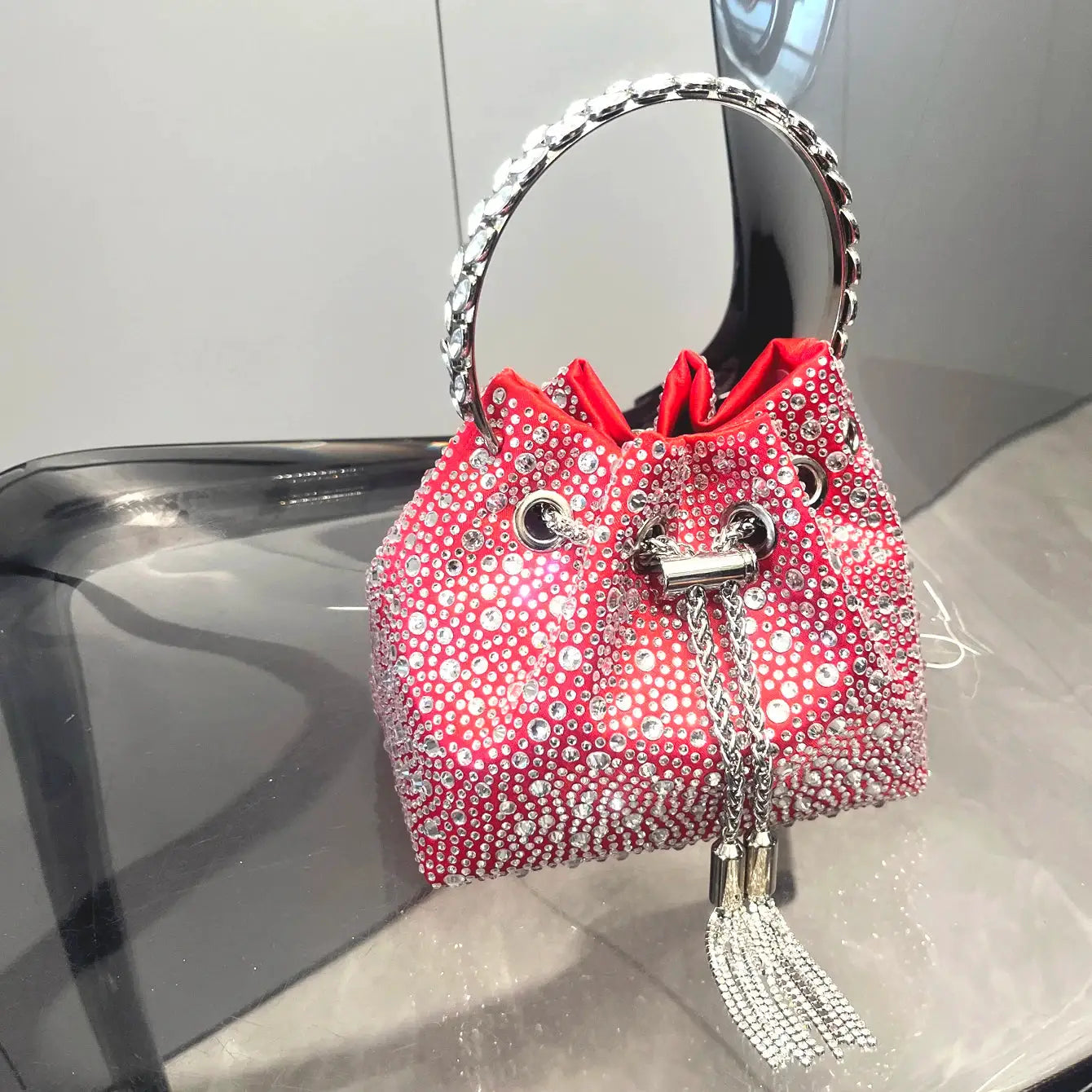 Red rhinestone evening clutch with crystal studs, round jeweled handle and silver tassel.
