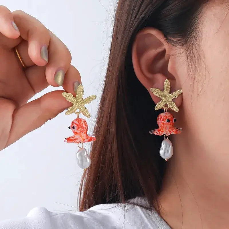 Octopus earrings pair with gold starfish tops, orange glass octopus charms and white pearl drops, Simples Market