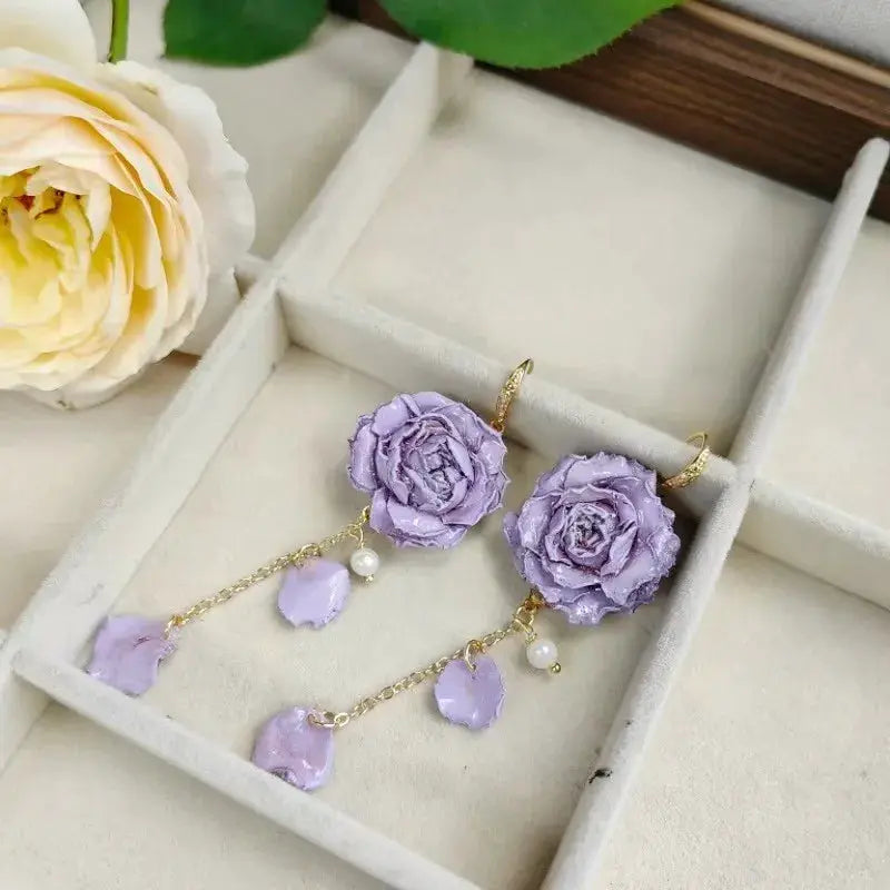 Earrings: lavender rose long epoxy resin with gold chains and pearl accents.