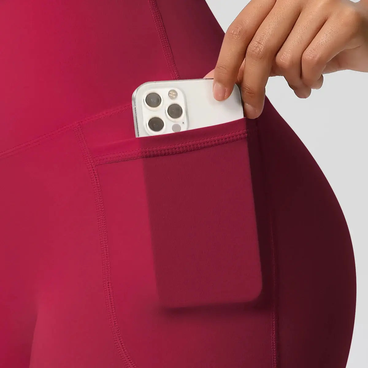 Women’s pocketed yoga shorts in magenta with side phone pocket.