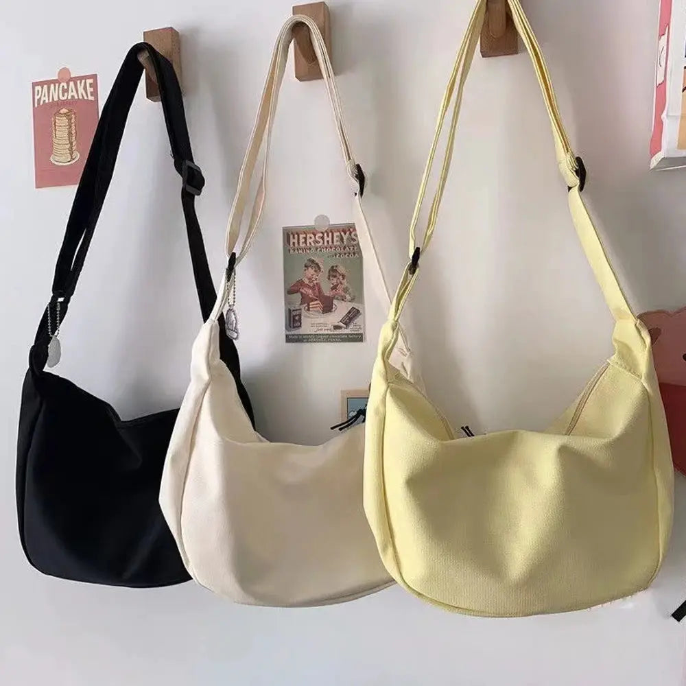 Three women's shoulder bags in black, cream, and pale yellow with adjustable straps and large capacity