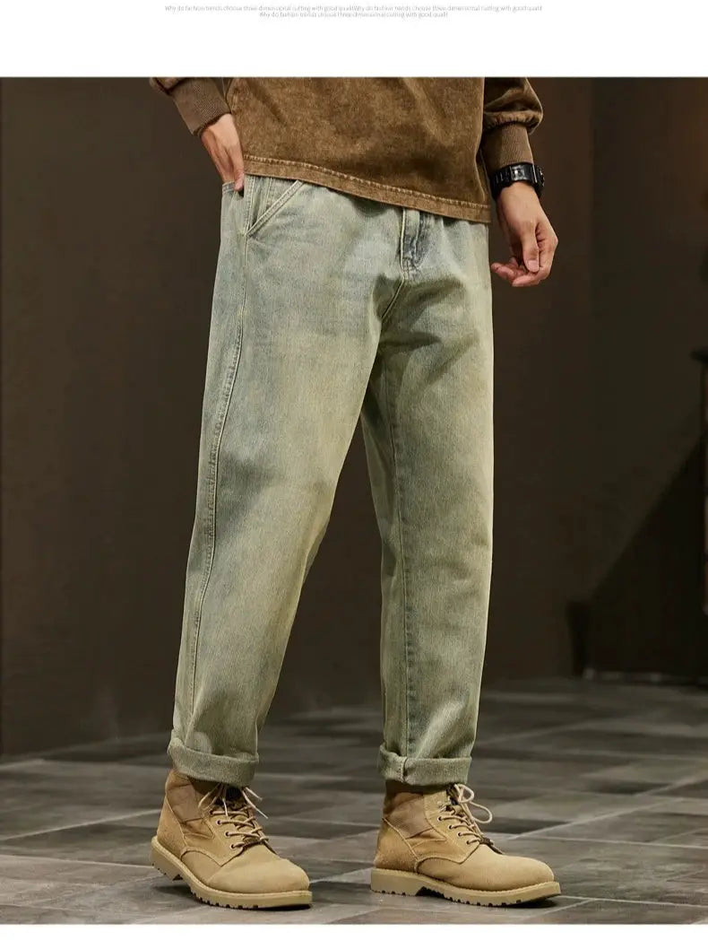 Men's loose-fit denim jeans, light-wash with cuffed hems, paired with tan work boots
