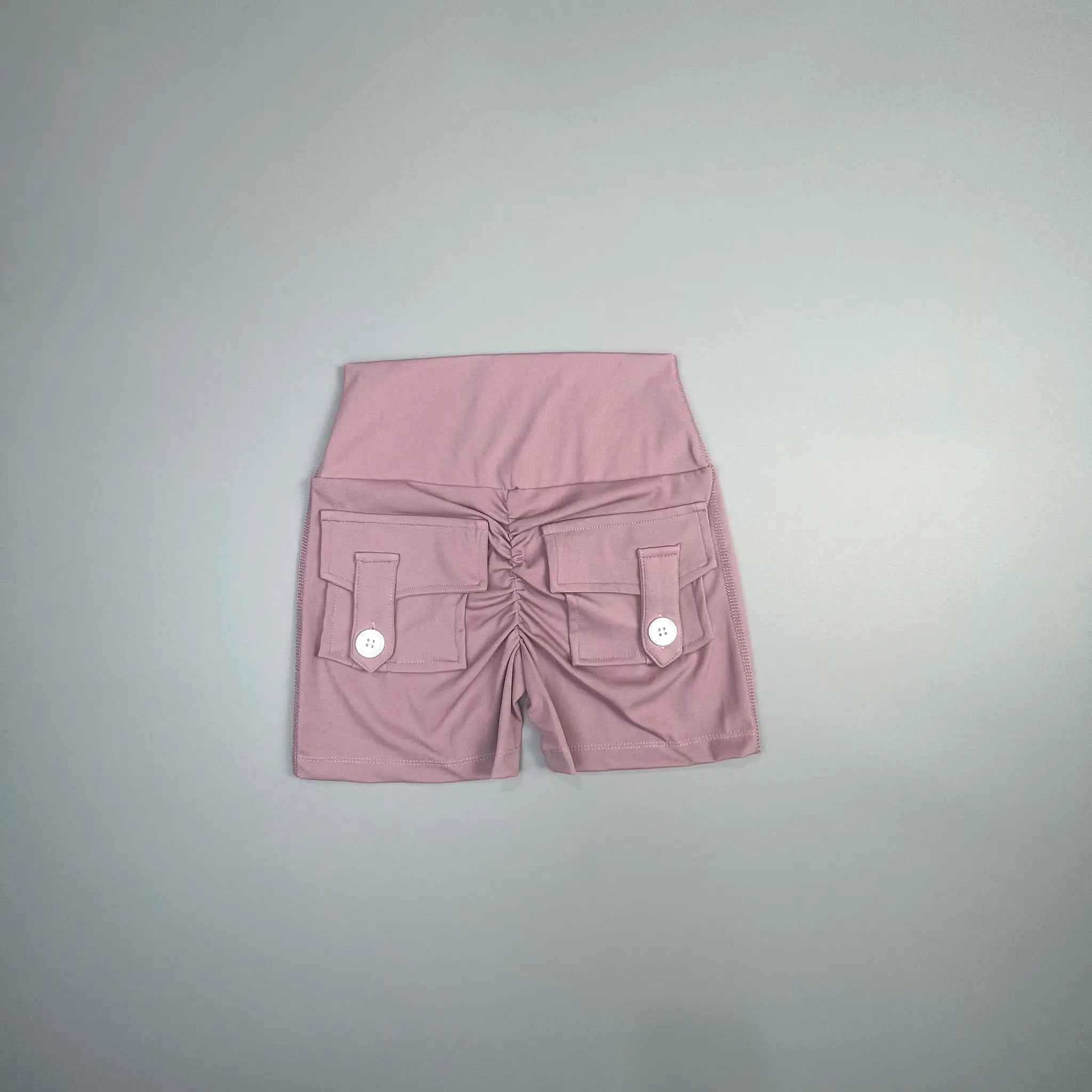 Women's peach pink cargo shorts with front pockets and white button flaps.