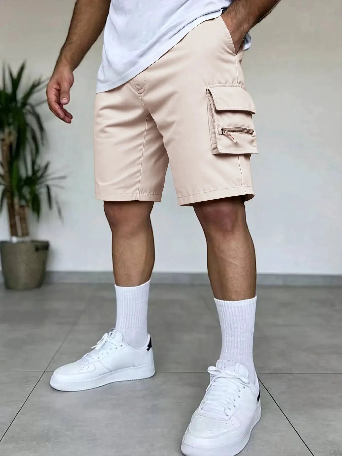 Beige men's cargo shorts with elastic waistband and side cargo pocket with flap, ideal for outdoor hiking.