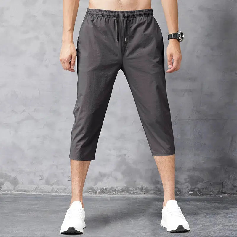 Men's 3/4 length quick-dry nylon shorts in dark gray with elastic waistband and drawstring
