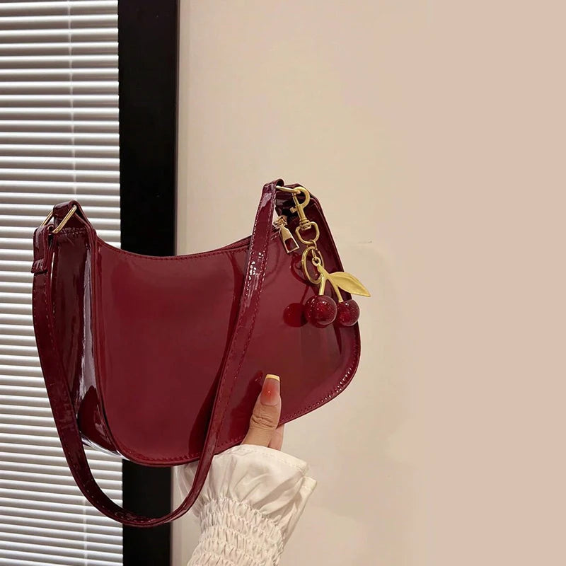 Women's burgundy PU leather shoulder bag with cherry pendant charm and gold hardware