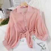 Pink chiffon blouse with front waist tie, bat-wing sleeves, and button placket