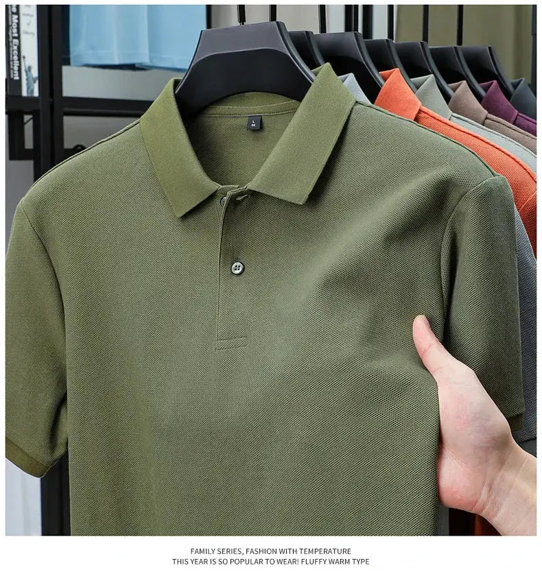 Men's olive-green 100% cotton polo shirt on display with assorted colors in the background