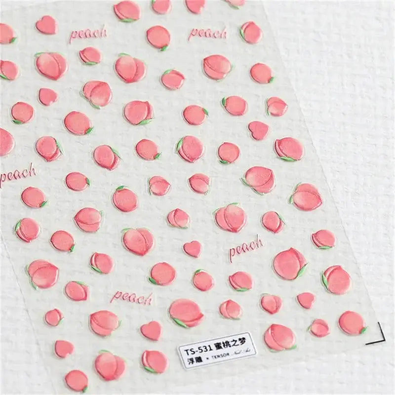 Nail art stickers sheet featuring pink peach motifs with green leaves on a clear background.