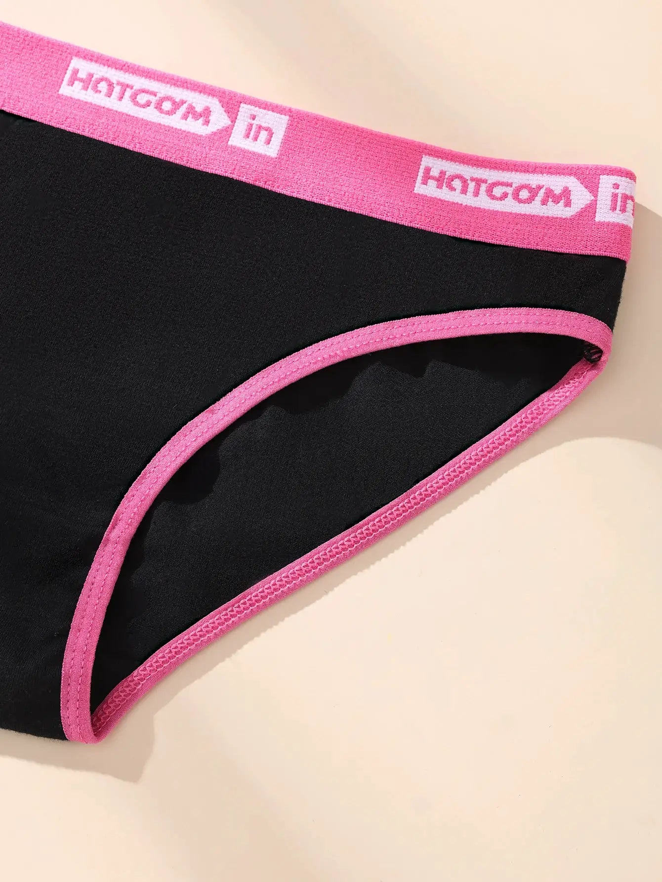 Women’s black cotton panties with pink elastic waistband and trim, breathable stretchy fabric.