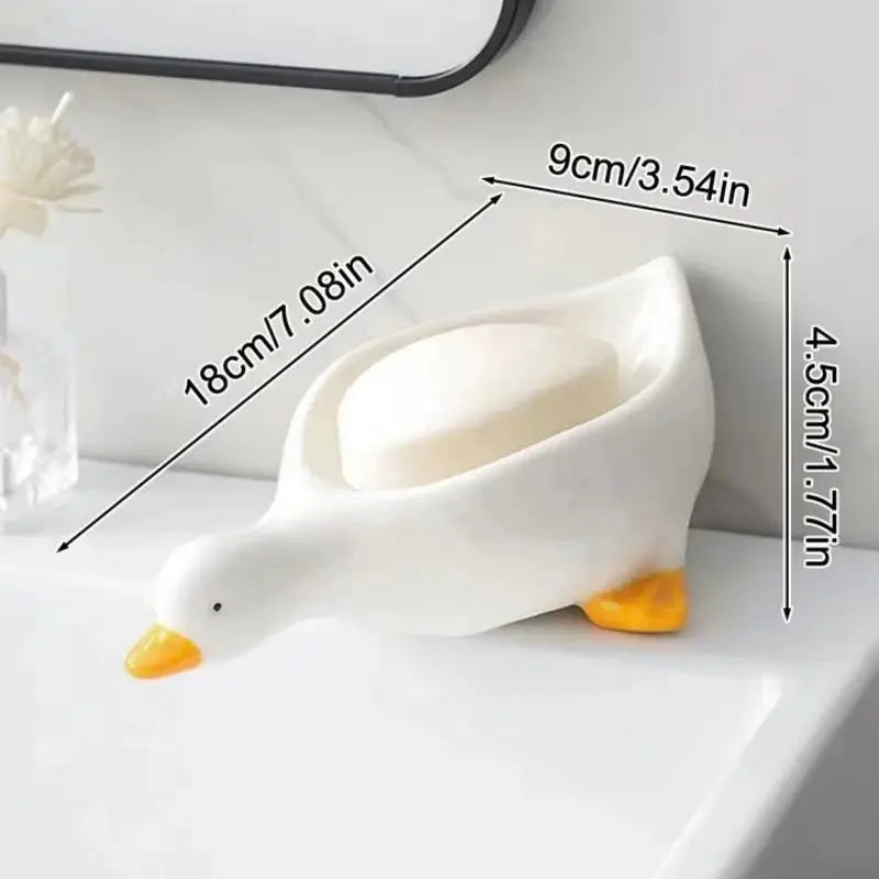 Duck-shaped self-draining soap tray, white with orange beak; 18 cm long, 9 cm wide, 4.5 cm tall.