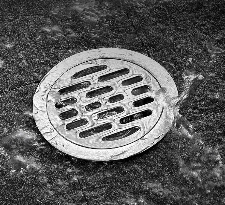 Stainless steel floor drain with round oblong-slotted grate for shower or bathroom, hair catcher