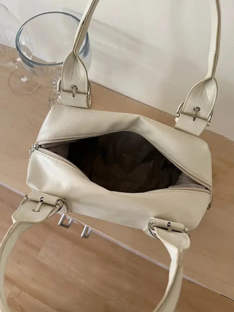 Shoulder bag by Simples Market; cream PU leather with rivet hardware and open top showing dark interior