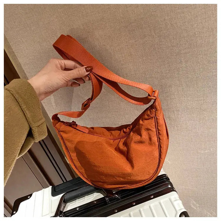 Casual nylon hobo crossbody bag in orange with adjustable strap, large capacity.