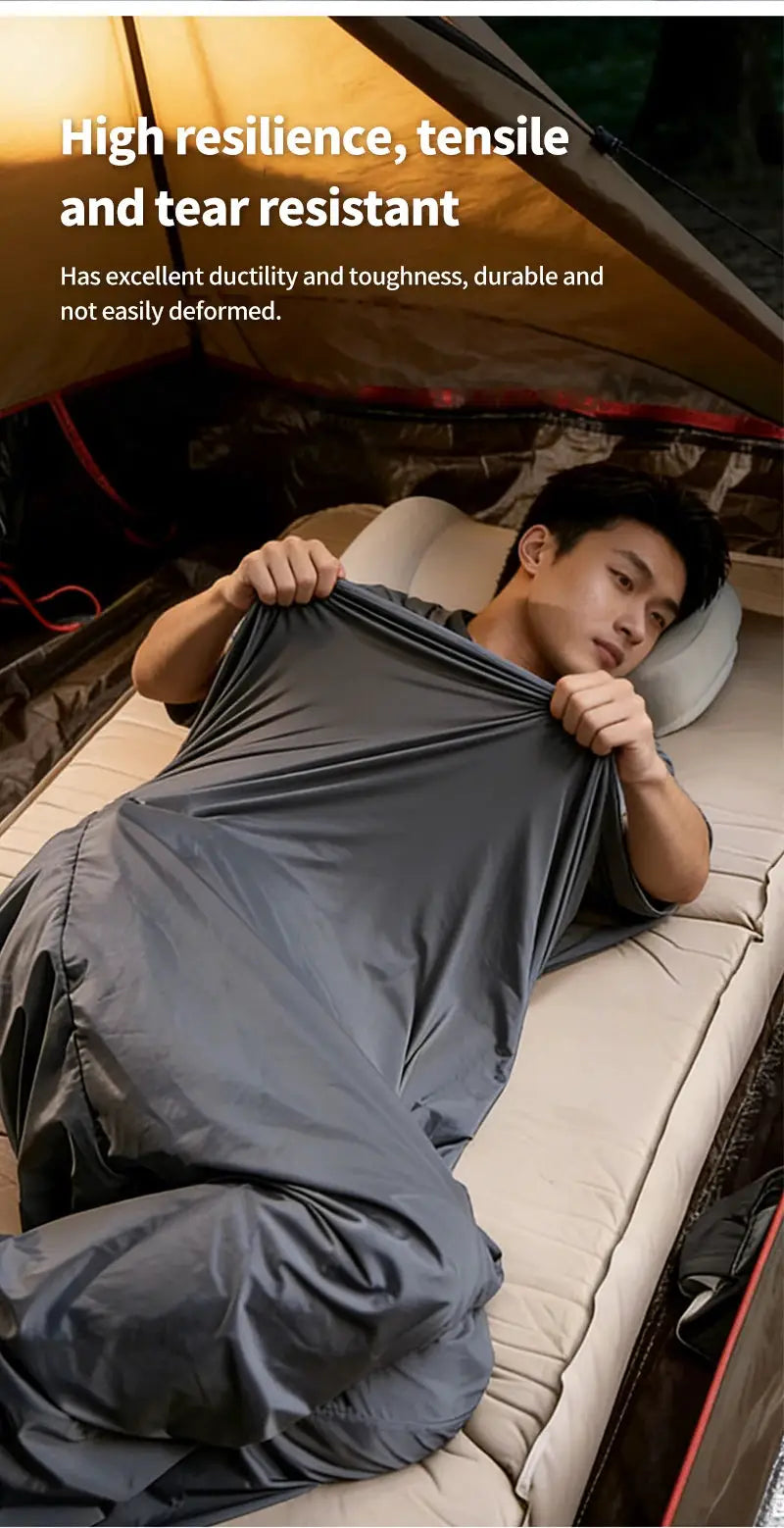 Gray envelope-style sleeping bag liner with a person in a tent; ultralight 128g camping gear