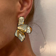 Earrings by Simples Market; metal irregular pleated petal design in gold and silver tones with black edges.