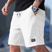 Men's white textured breathable shorts with drawstring waistband, casual beachwear.