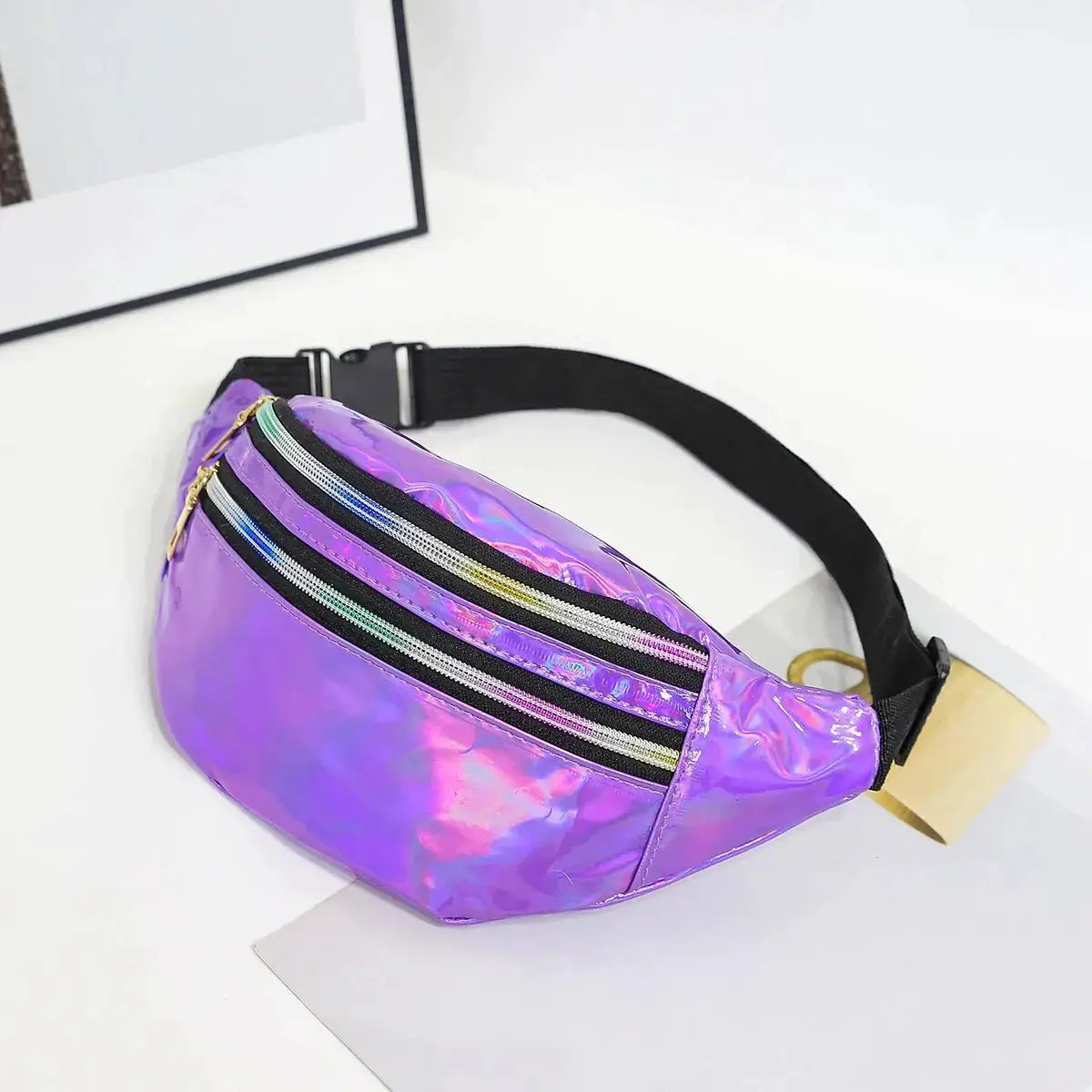 Holographic purple waist bag with three zip pockets and an adjustable black strap.