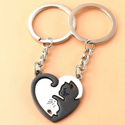 Cute Cat Hug Keychain set; stainless steel heart pendant with black and white cats cuddling, on two silver rings
