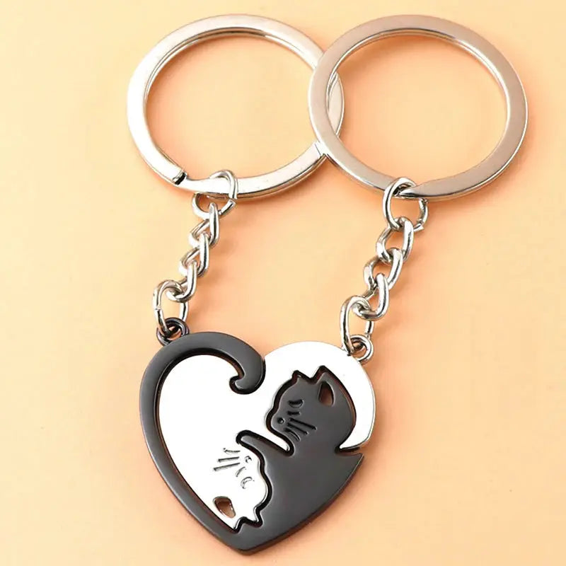 Cute Cat Hug Keychain set; stainless steel heart pendant with black and white cats cuddling, on two silver rings