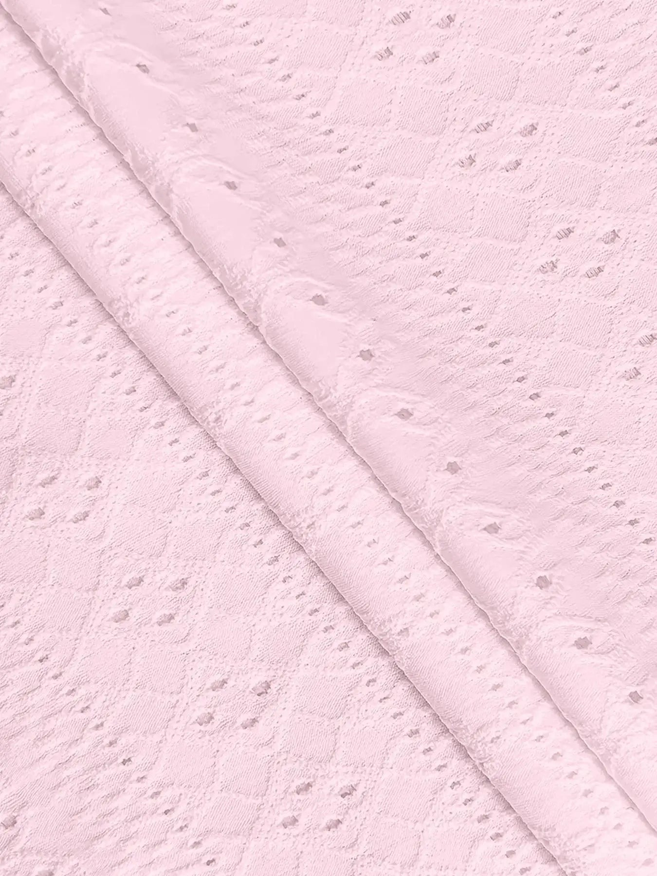Pink lace fabric close-up with dotted eyelet pattern