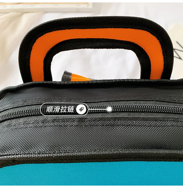 Backpack for primary school students; black body with orange padded handle and teal panel.