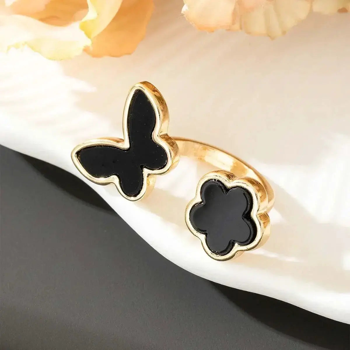 Simples Market Exaggeration Punk ring set, two gold-tone rings with black enamel floral shapes