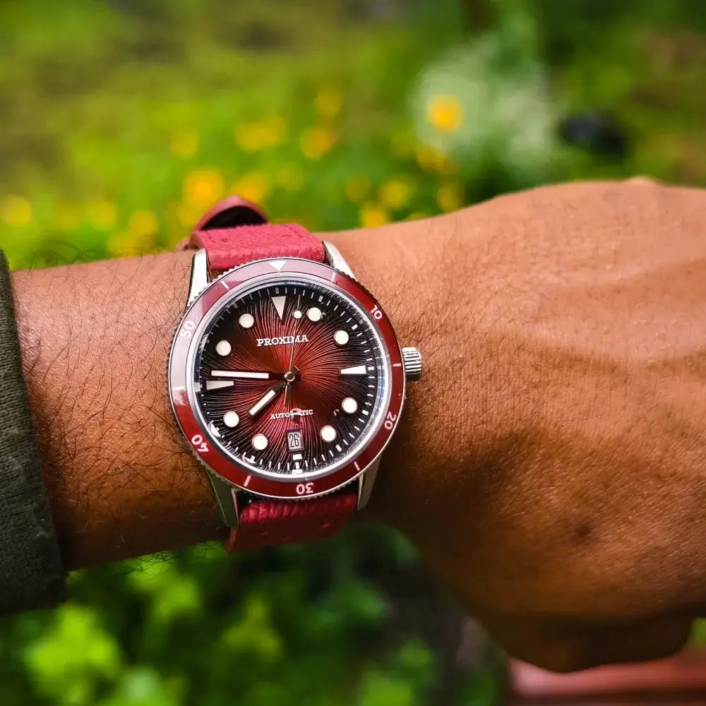Proxima 39mm dive watch on wrist with red sunburst dial, red bezel, automatic movement, luminous markers, red strap