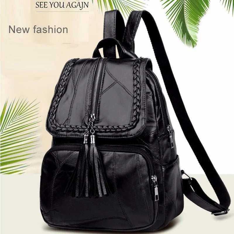 Mini black men's backpack with braided trim, tassel zipper pulls, front pocket, and adjustable shoulder straps.