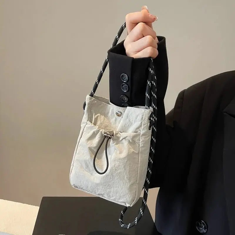 Nylon crossbody bag by Simples Market; light gray mini square purse with black-and-white patterned strap.