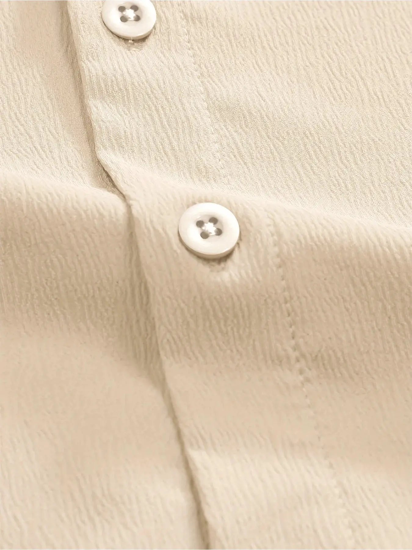 Summer men's short-sleeve linen shirt in beige with white buttons, textured fabric close-up