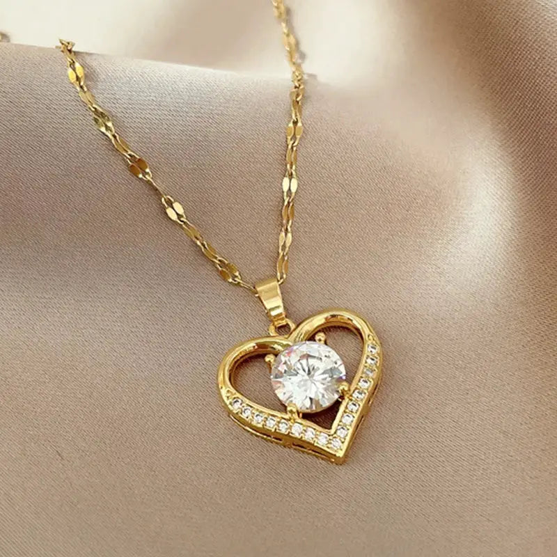 Gold-tone heart pendant necklace with a large center crystal and pave crystal outline on a matching chain