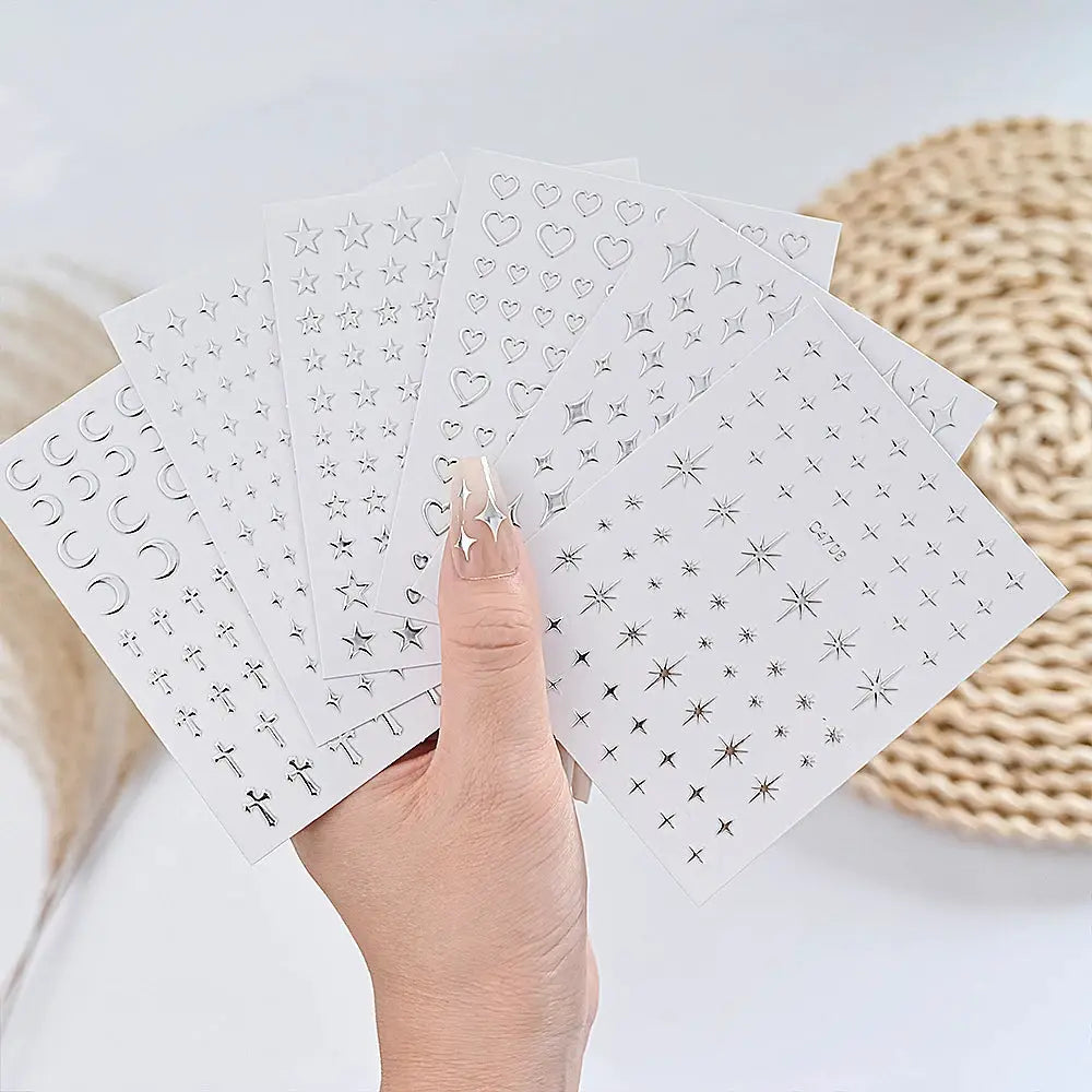 Nail sticker sheets: six sheets of silver metal self-adhesive stickers by Simples Market with stars, hearts, and moons.
