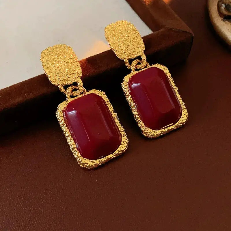 Pair of vintage red resin geometric oval drop earrings with gold-tone textured frames